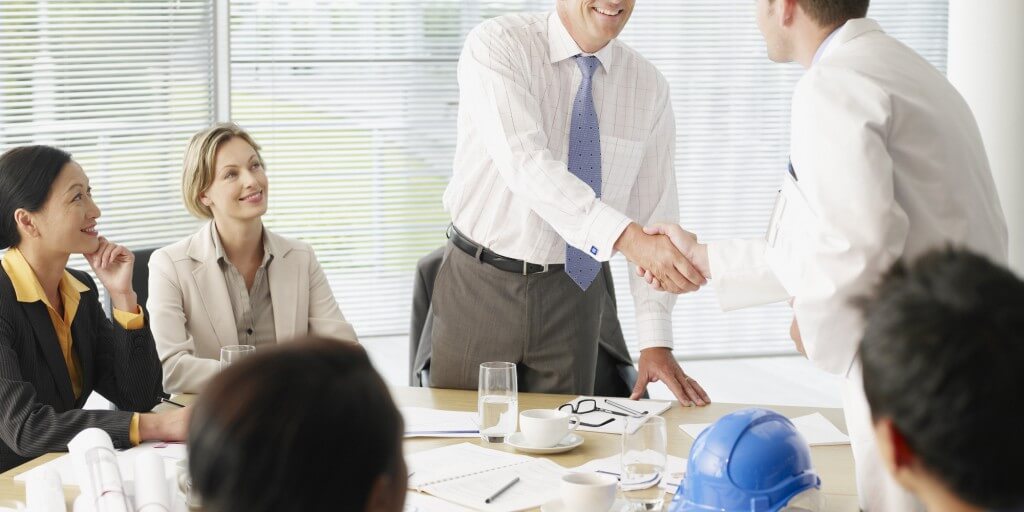 Businesspeople shaking hands in conference room